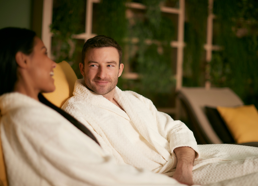 Man and woman sitting talking inside the spa.