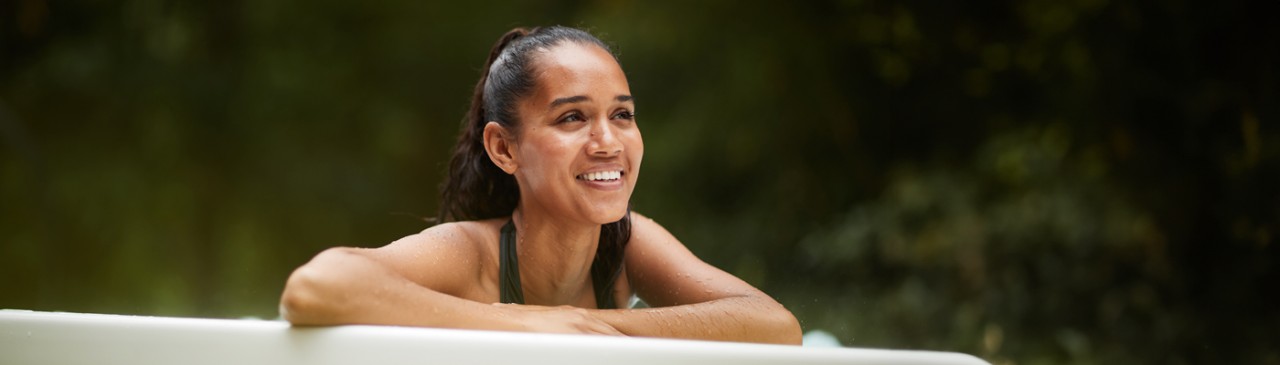 Woman leaning over the edge of a bubbling hot tub