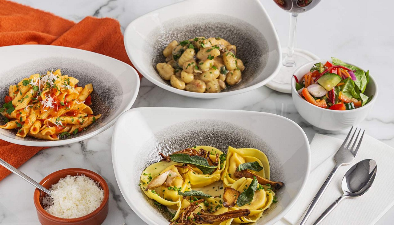 Selection of pasta dishes served with a side salad.