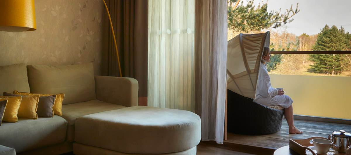 Woman sitting on a twin bed in a Spa Suite reading a book.