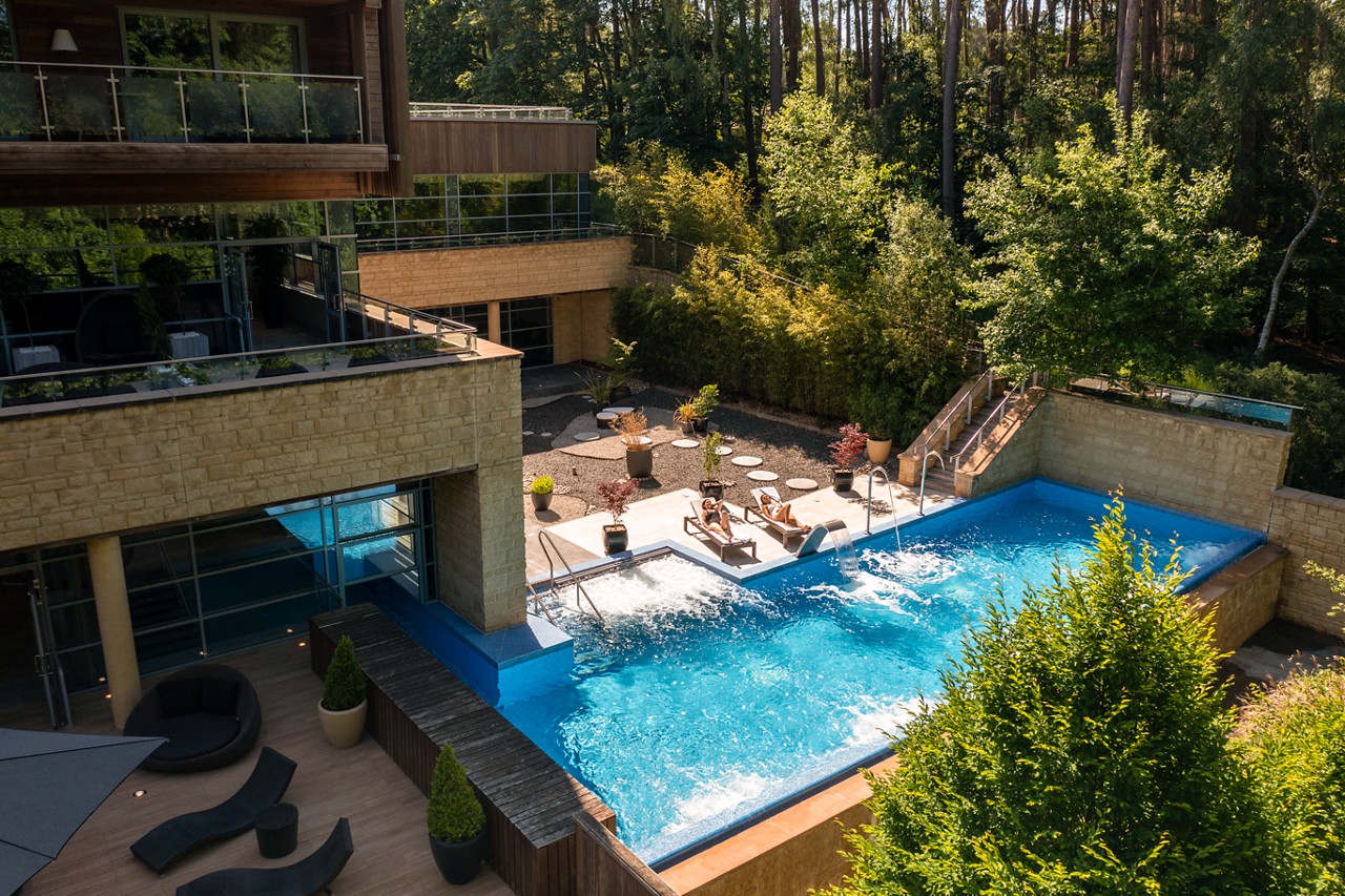 Outdoor Pool and sun loungers surrounded by the forest.