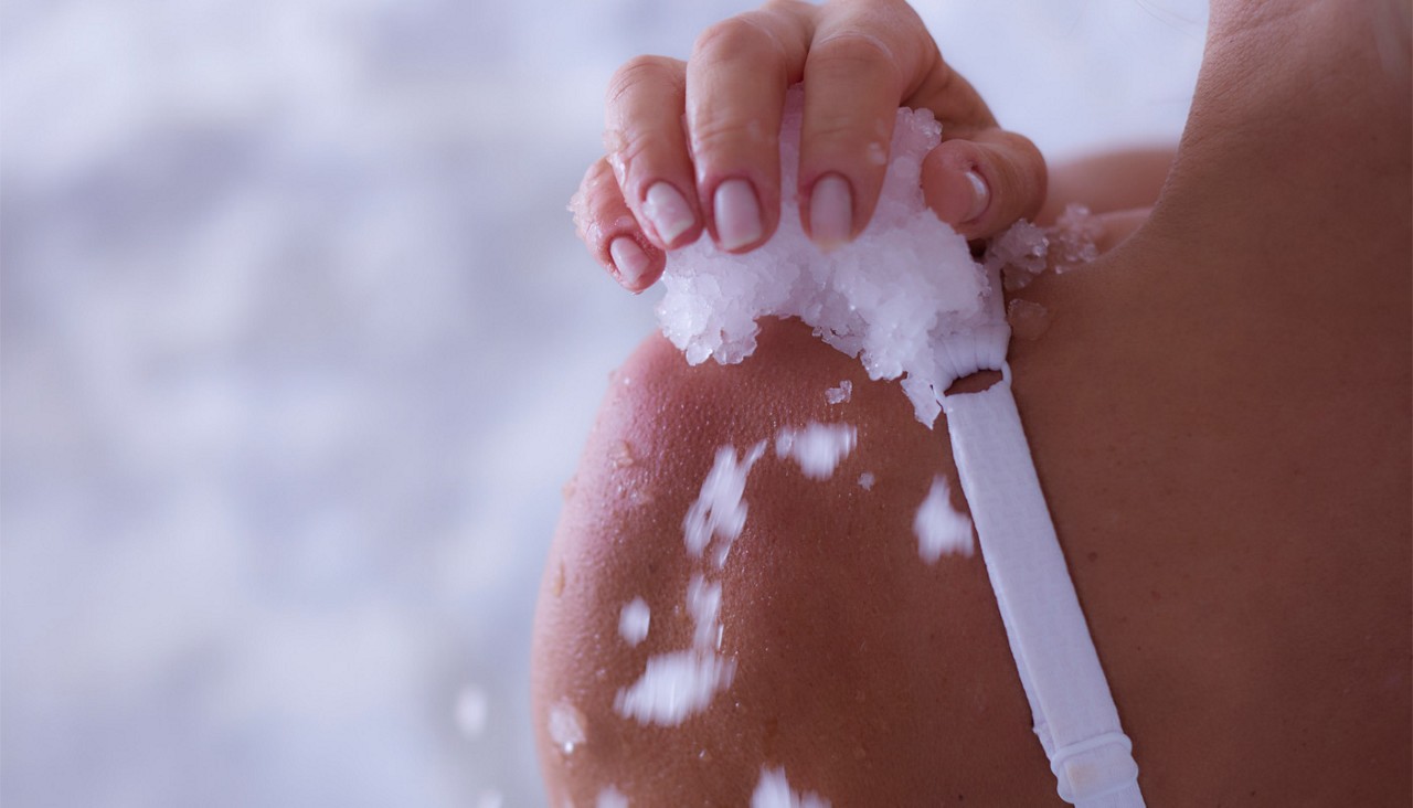 Woman rubbbing ice across her skin.