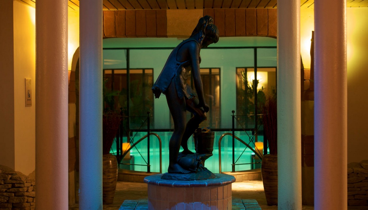 Statue in front of an outdoor pool.
