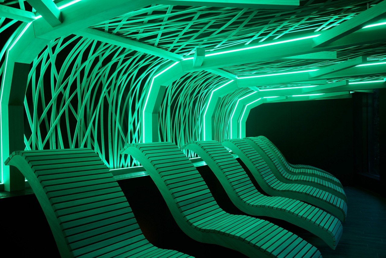 Glowing decorative design above wooden contoured lounge chairs.