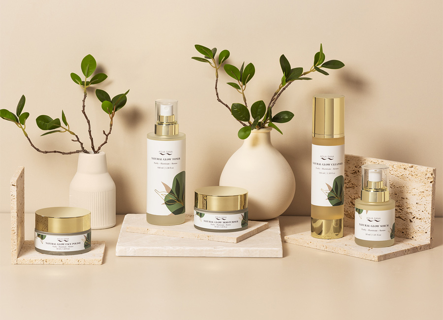 Aqua Sana natural gloe products lined up with decorative foliage.