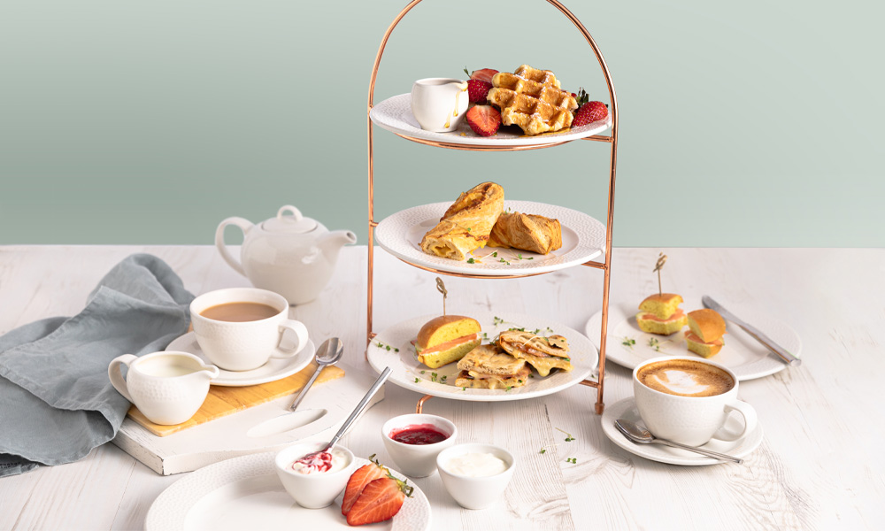 Stacked Afternoon Tea served with a pot of tea.