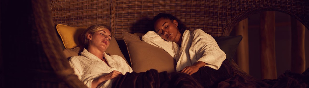 two women laid on comfy chair asleep