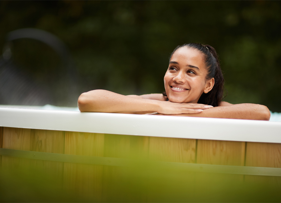 Woman resting on the edge of an outdoor hot tub
