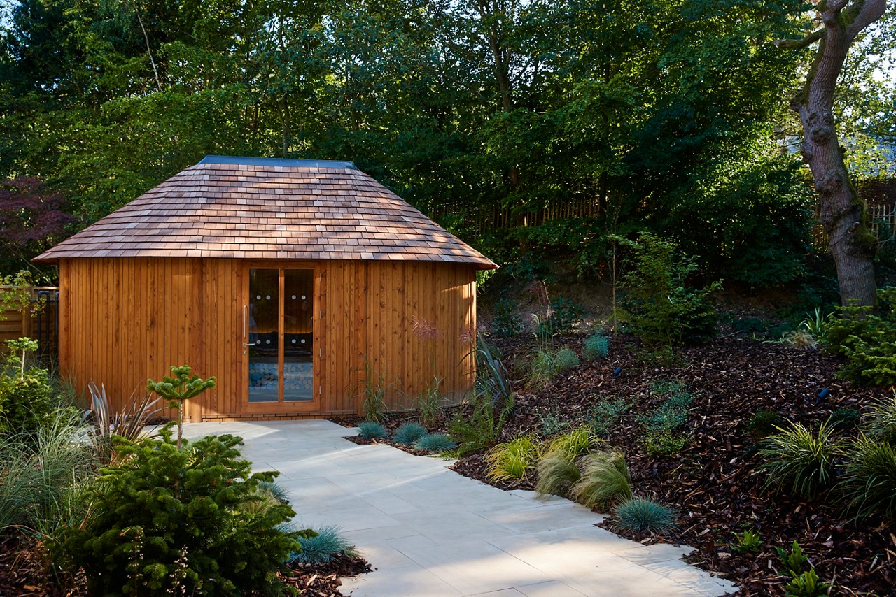 Path in the forest leading to a wooden Scandinavian Snug hut.