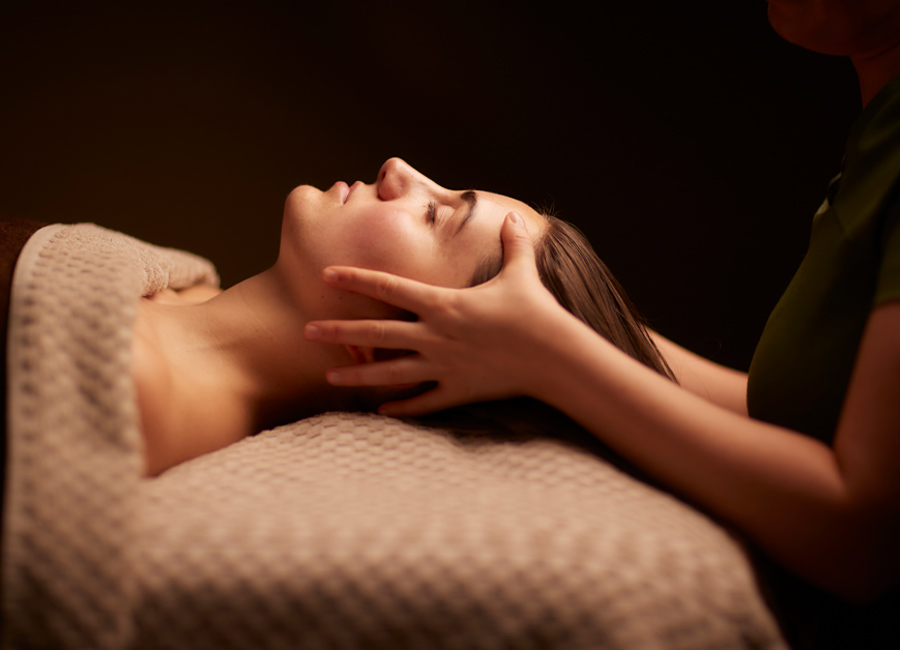 Woman having her head rubbed by a trained spa therapist.