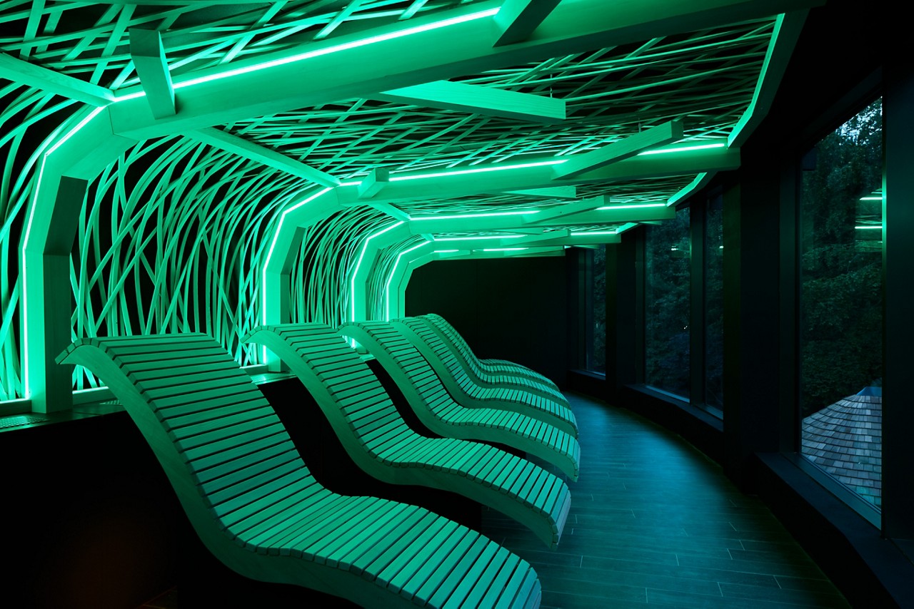 Glowing decorative design above wooden contoured lounge chairs.