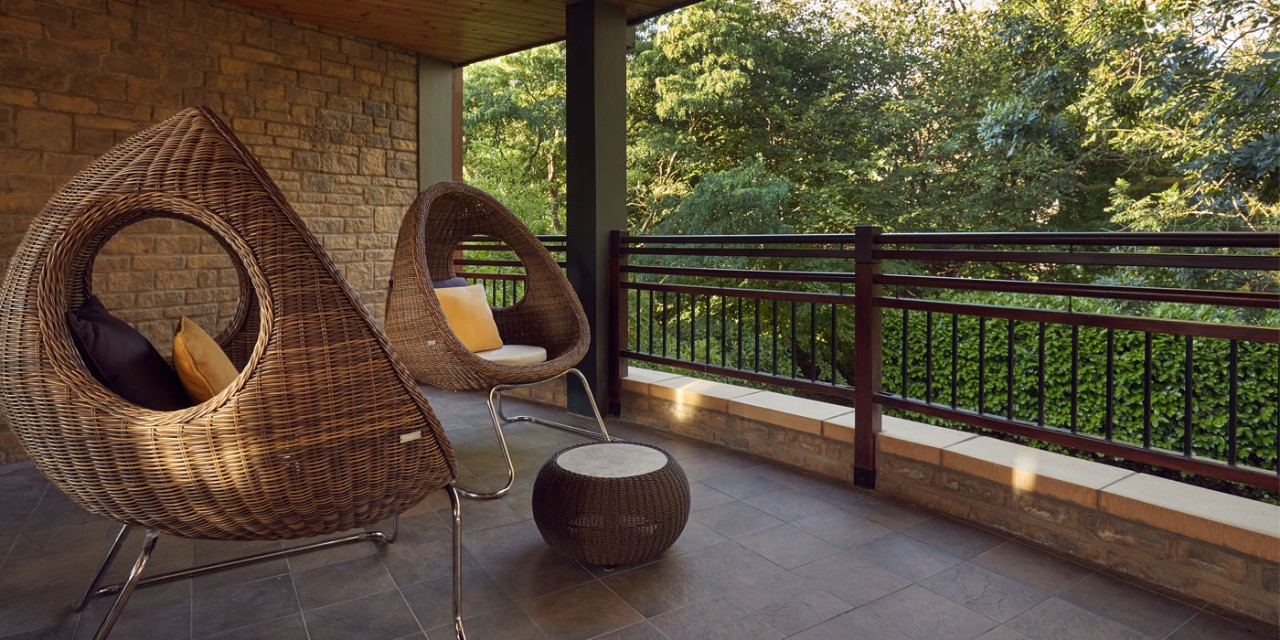 outdoor terrace with two chairs overlooking forest