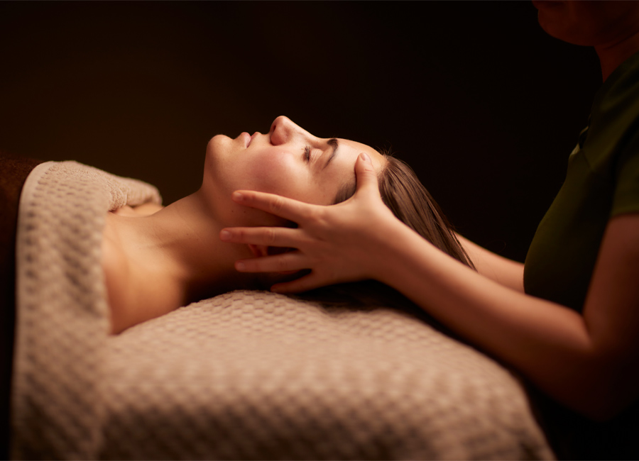 Woman having her head rubbed by a trained spa therapist.