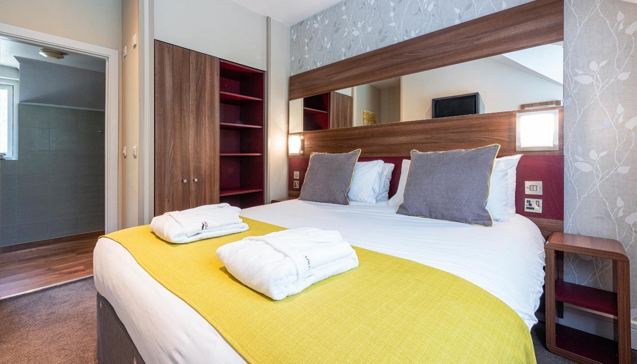 Double bed with neatly folded spa robes.