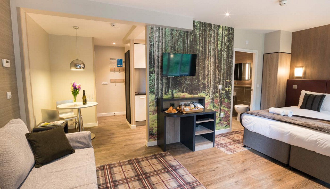 Studio apartment layout with a double bed, living space and en suite bathroom.