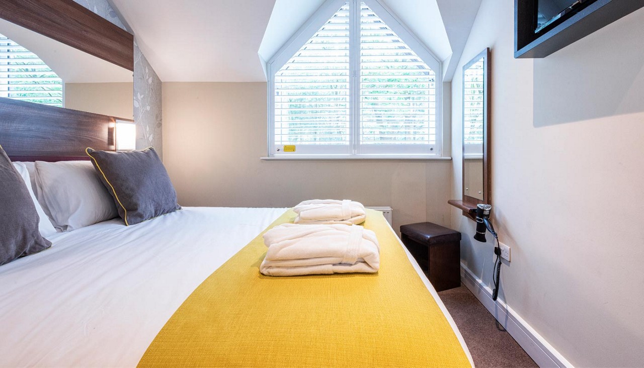 Double bed with neatly folded spa robes.