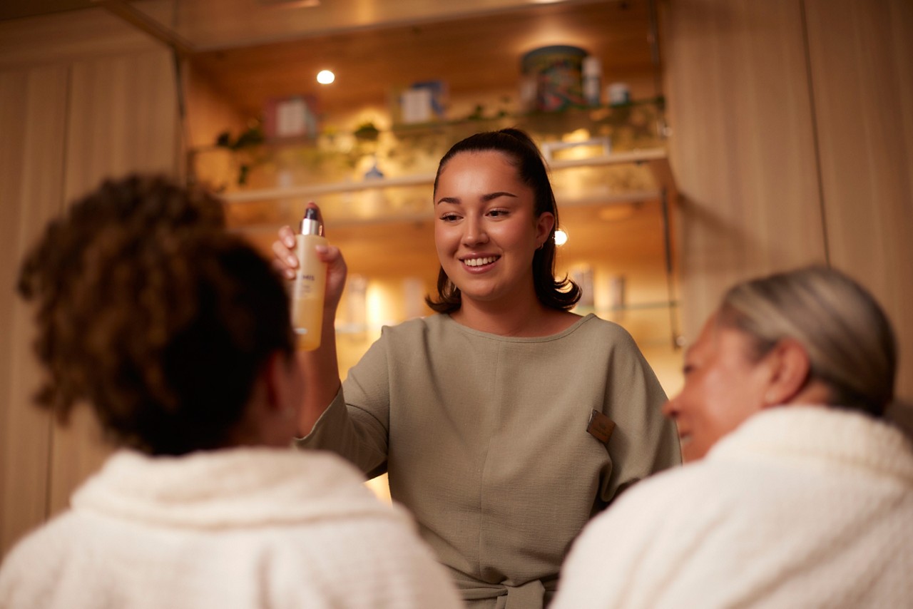 Therapist holding product bottle and demonstrating to clients 