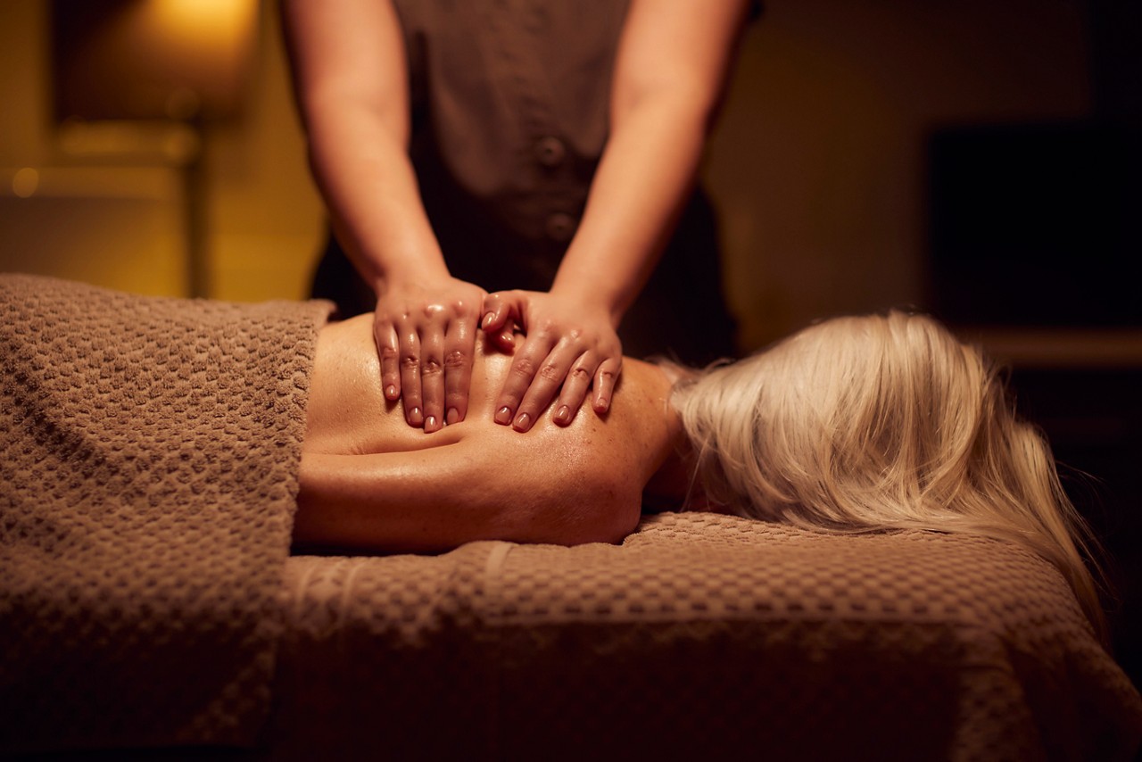 Spa therapist giving a woman a body massage treatment.