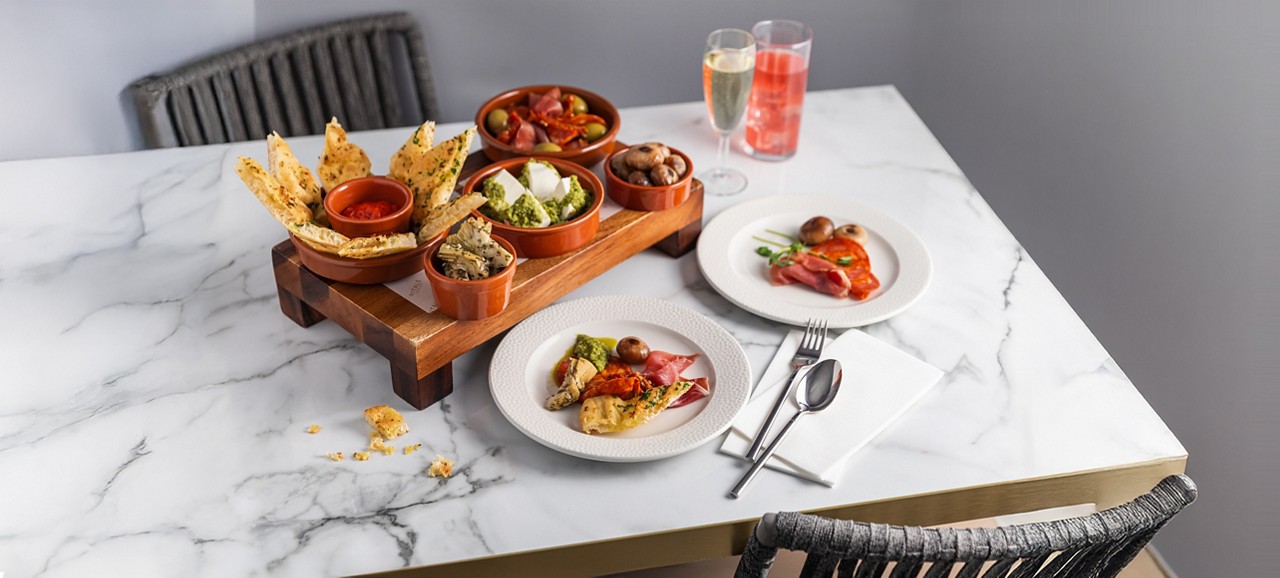 Platter including flat bread, dips and antipasti.