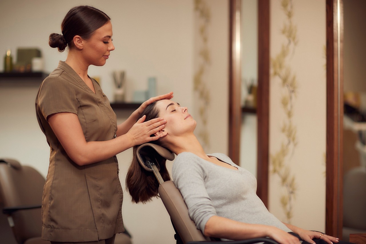 Spa therapist giving a client a relaxing head massage in the express treatment area.
