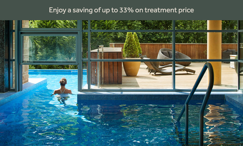 Woman soaking in an outdoor pool surrounded by the forest.