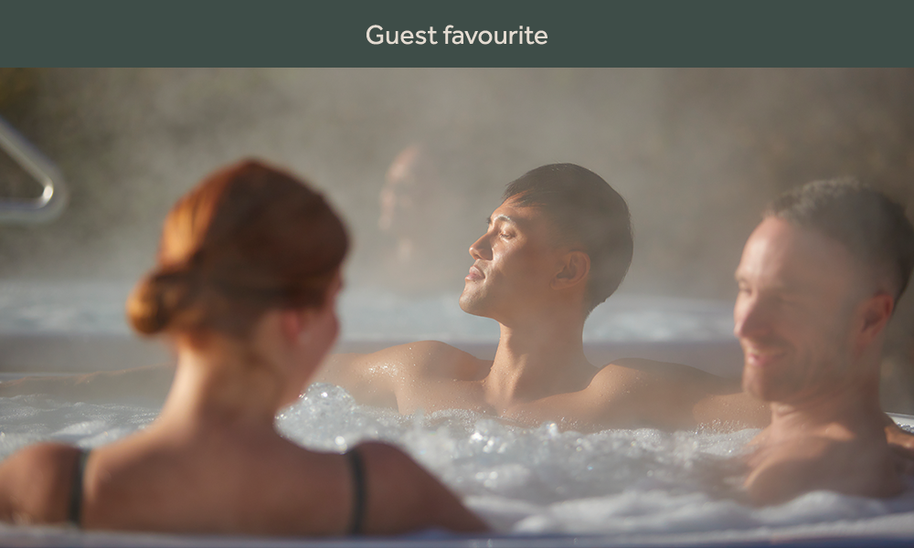 three people in an outdoor hot tub with steam surrounding them