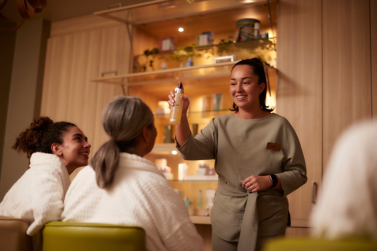Therapist holding product bottle and demonstrating to clients 