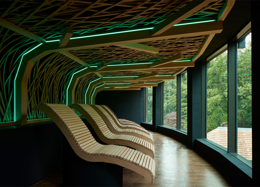 Wooden lounging chairs with a decorative ceiling design above.