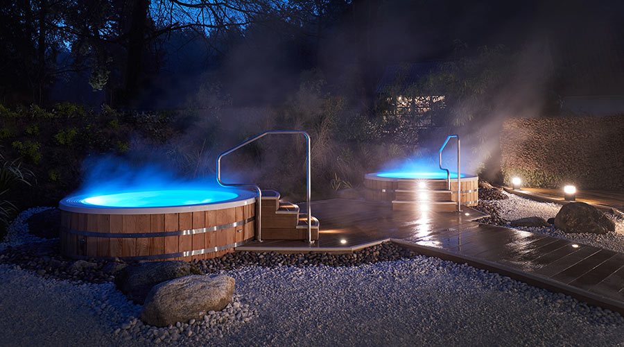 2 outdoor hot tubs at night time 