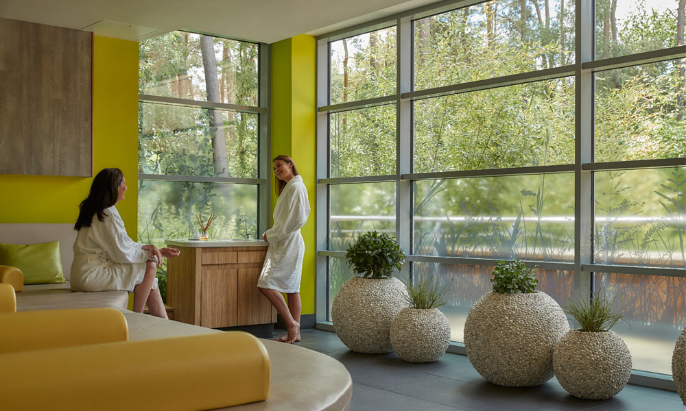 2 women chatting in forest view experience room