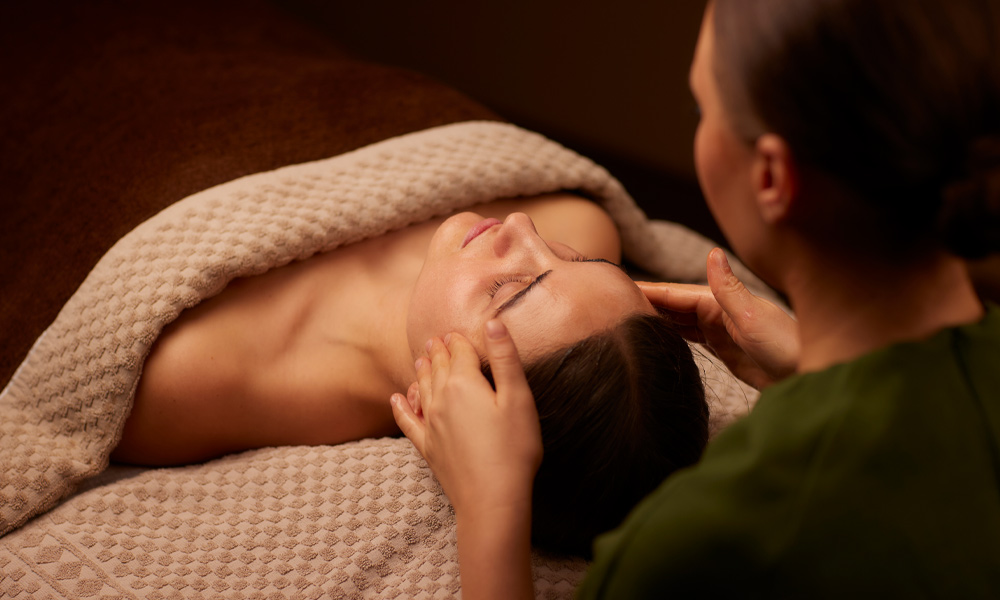 Spa therapist giving a women a relaxing facial treatment.