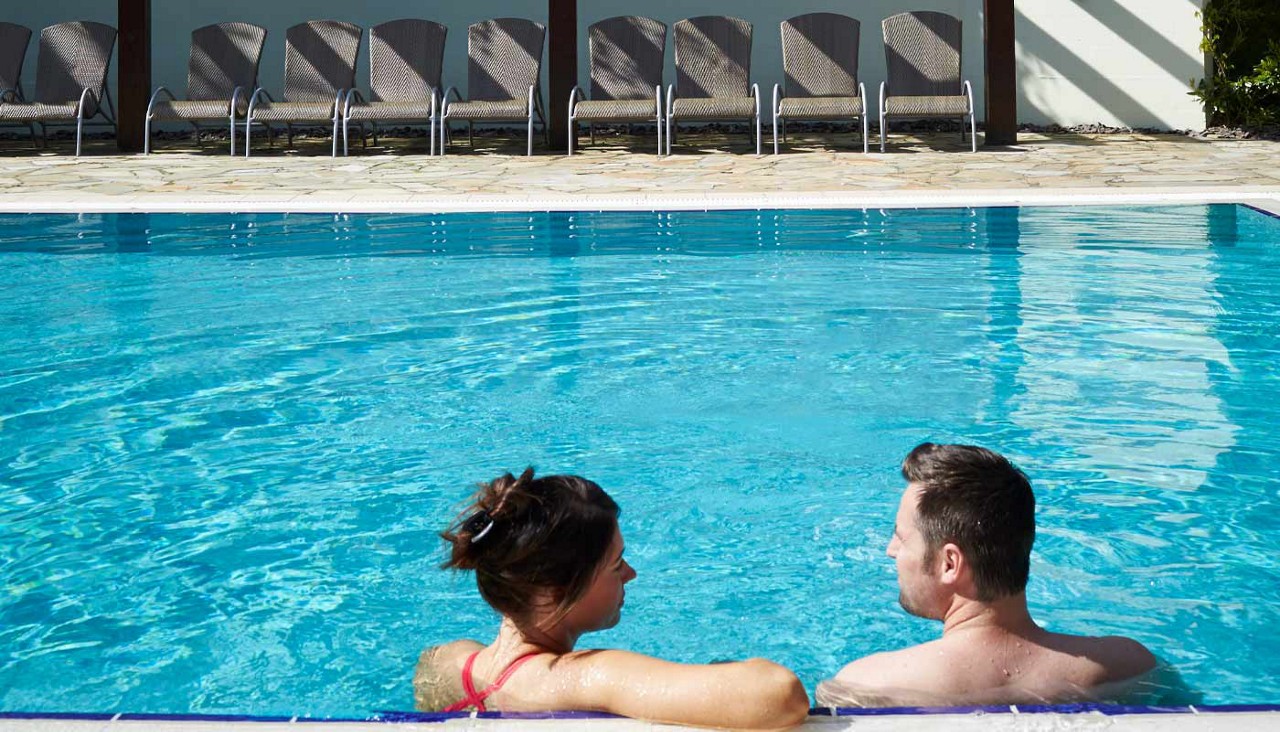 Couple soaking in an outdoor pool.