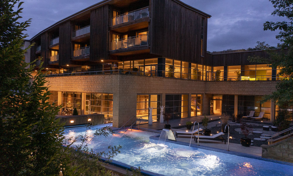 Flowing outdoor pool surrounded by luxury spa accommodation. 