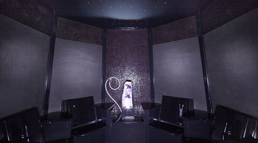 tiled experience room with black seats and illuminated crystal in the middle 
