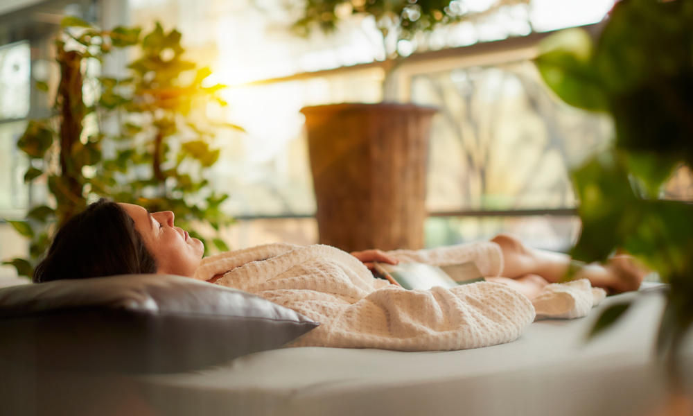 Woman laying on a waterbed in a light, natural space.