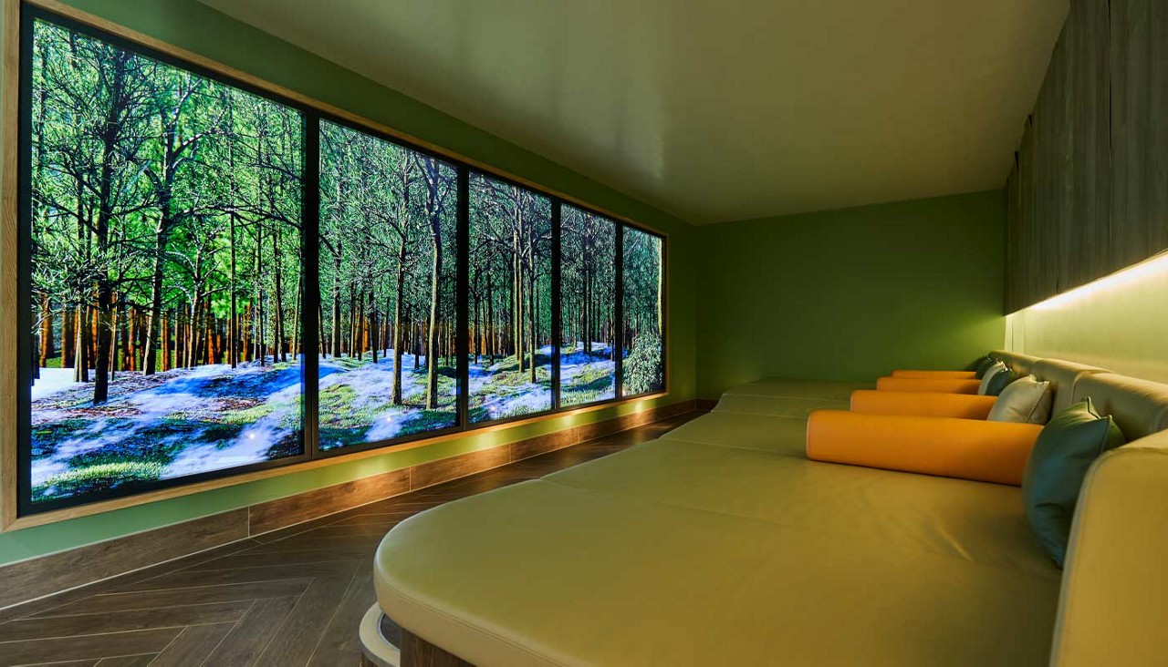 Curved green lounging area with throw cushions.