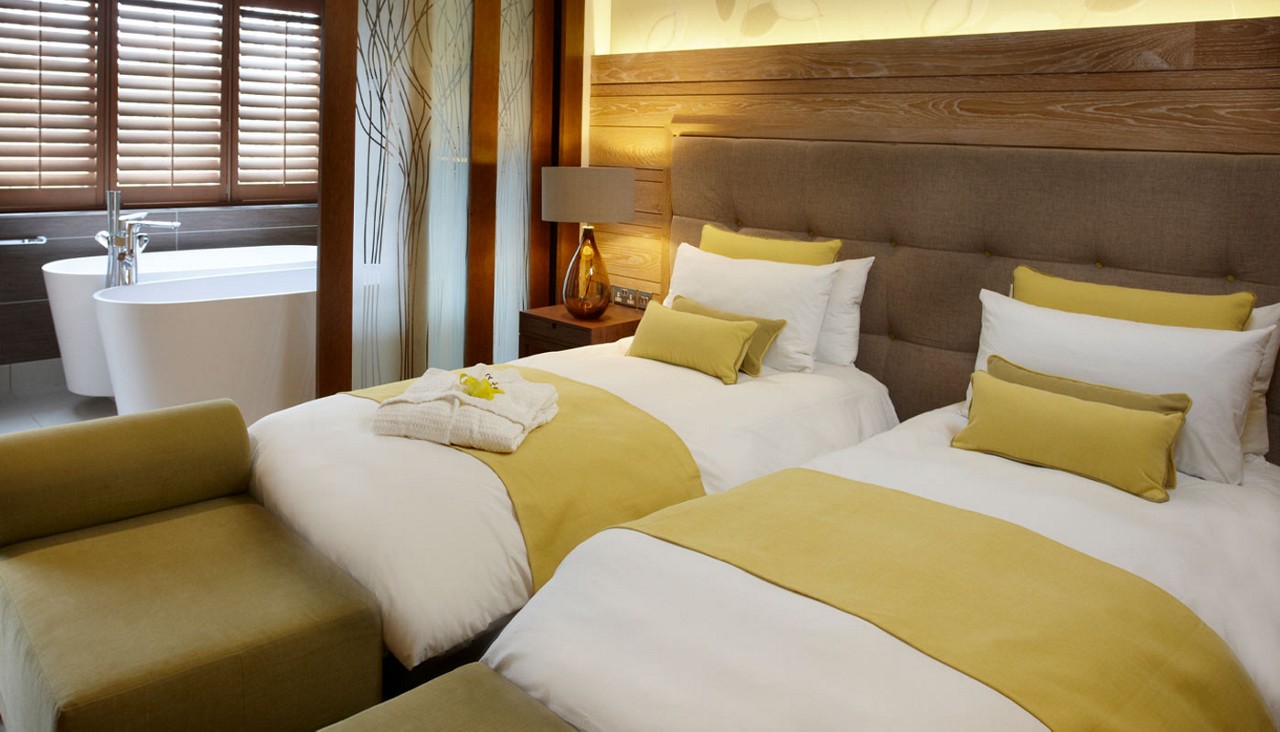 Twin beds with neatly folded spa robes.