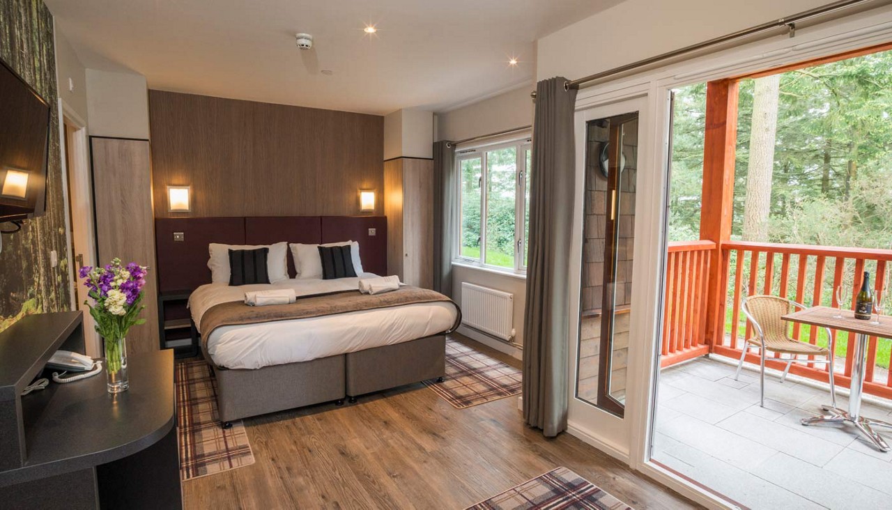 Double bedroom with a balcony with views out to the forest.
