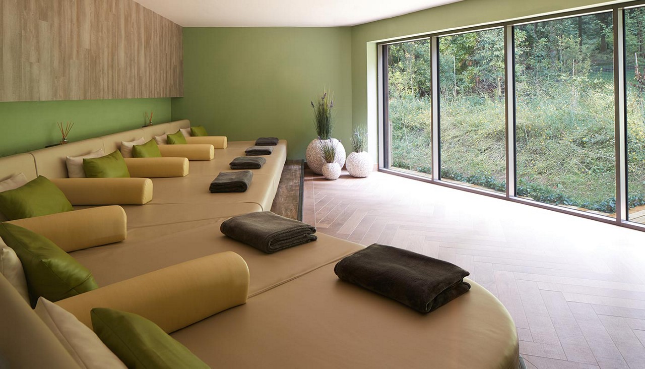 Curved green lounging area with throw cushions.