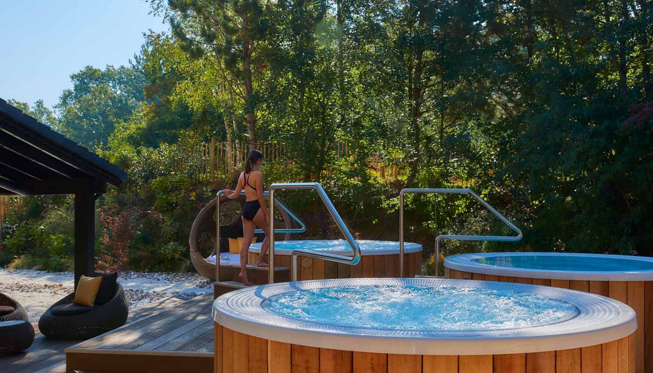 Woman stepping into a bubbling hot tub.