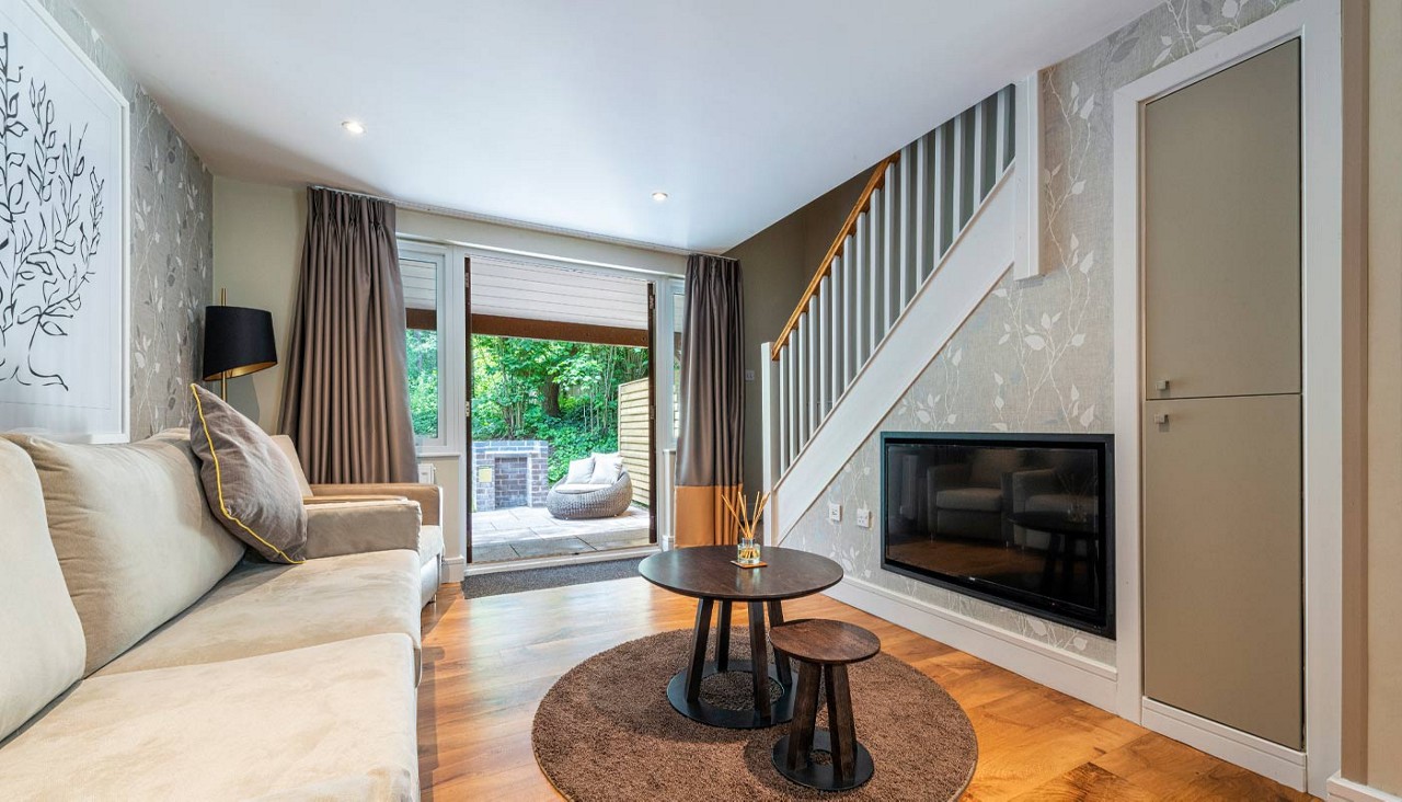 Living space with views out to an outdoor terrace surrounded by the forest.