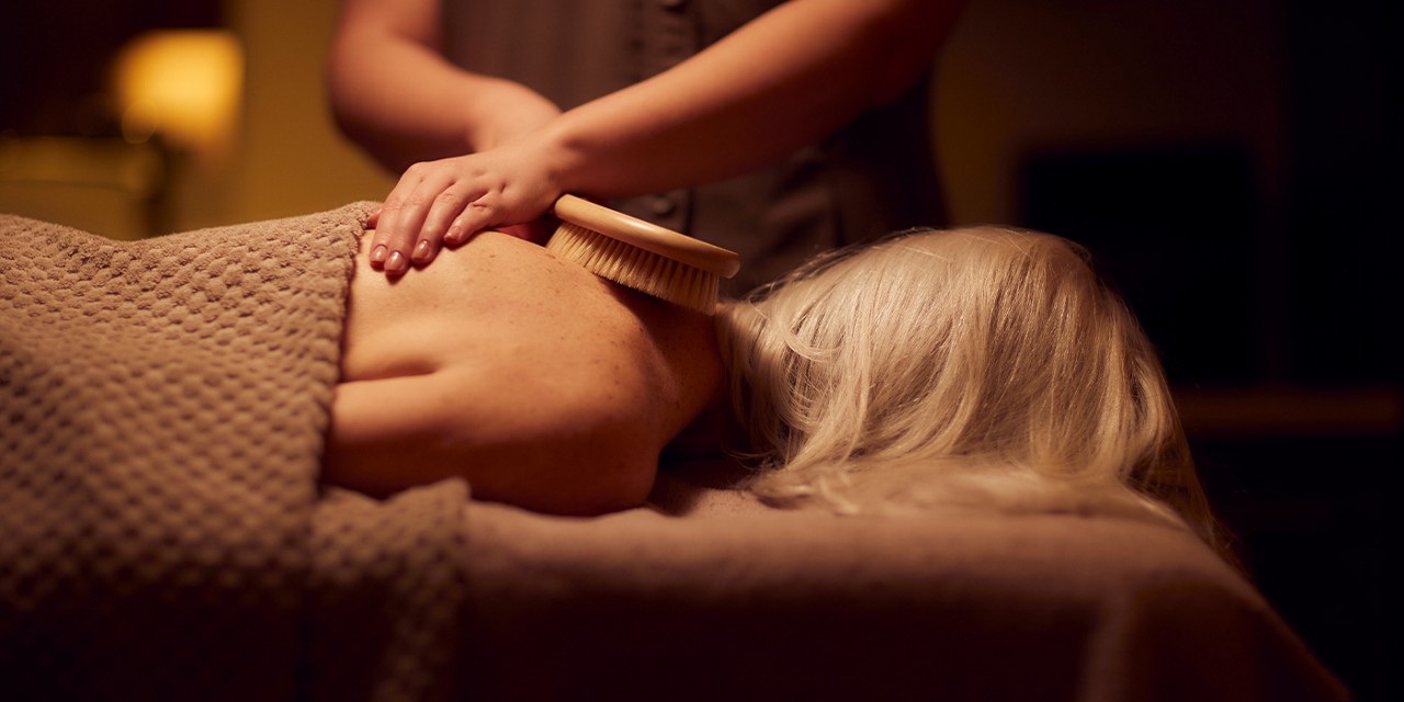 Woman having a brush stroked against her back.