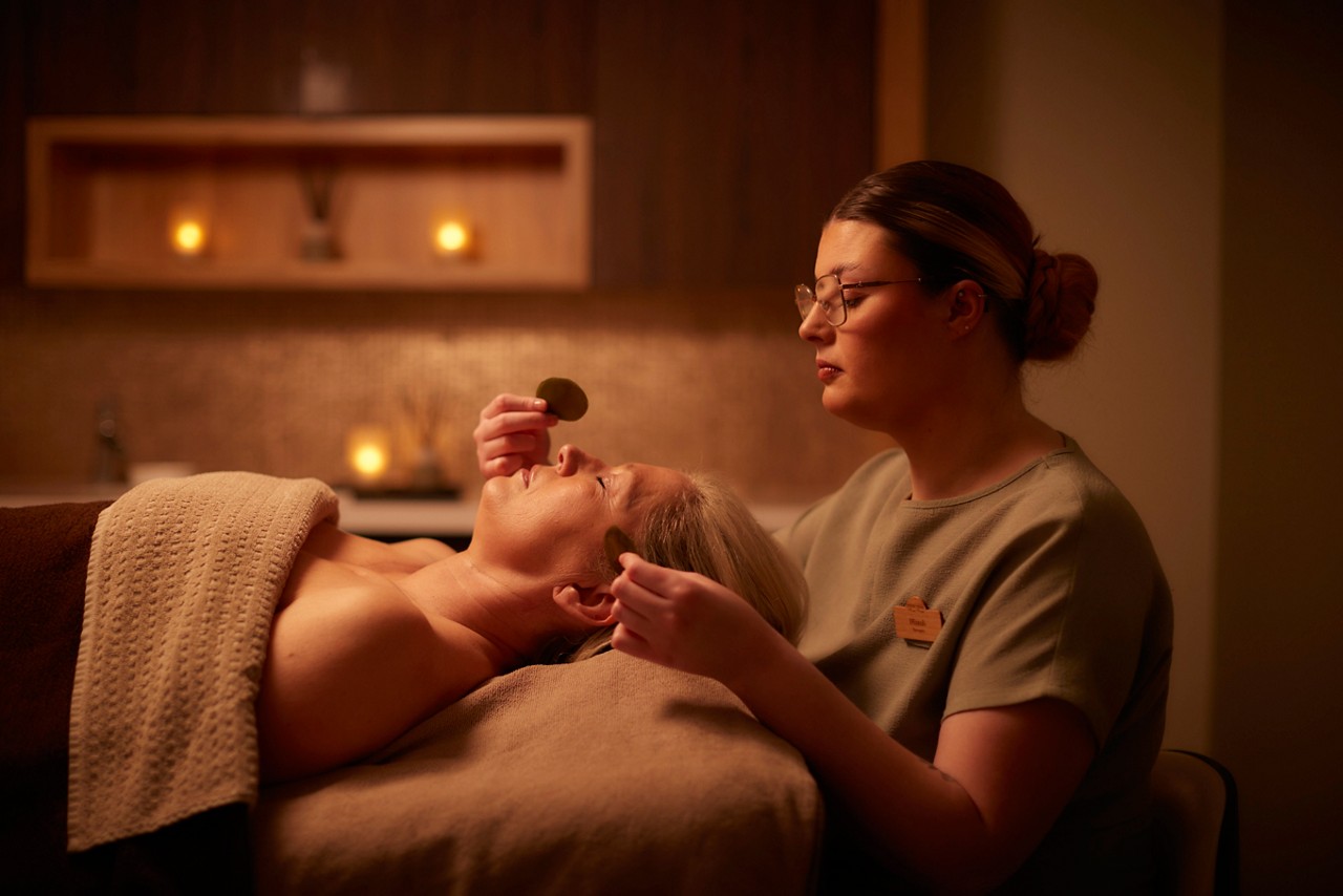 A spa therapist doing a facial treatment