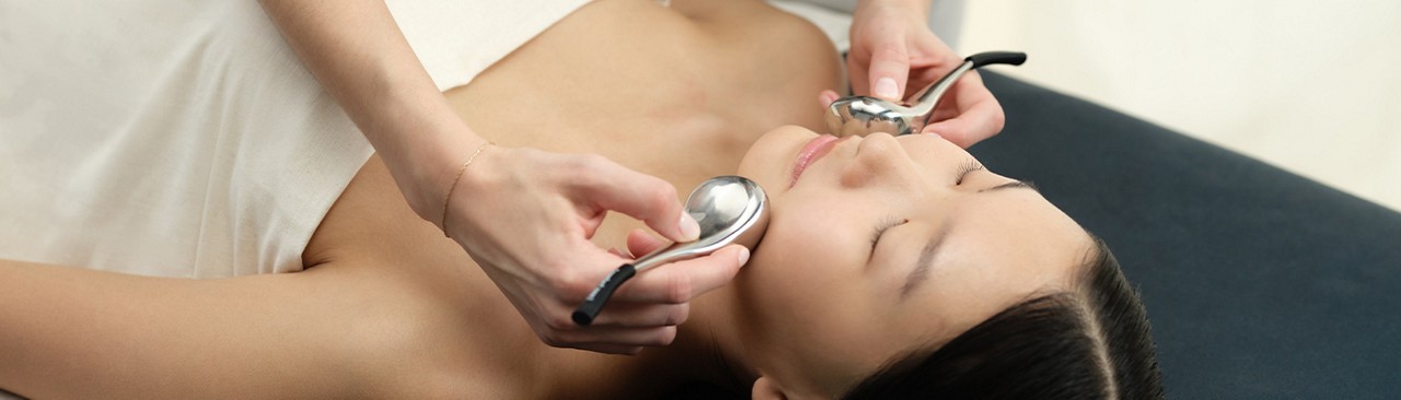 Woman having a facial with little brushes.