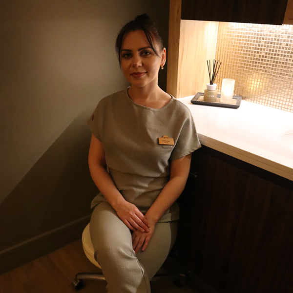 Spa therapist sitting in a treatment room.