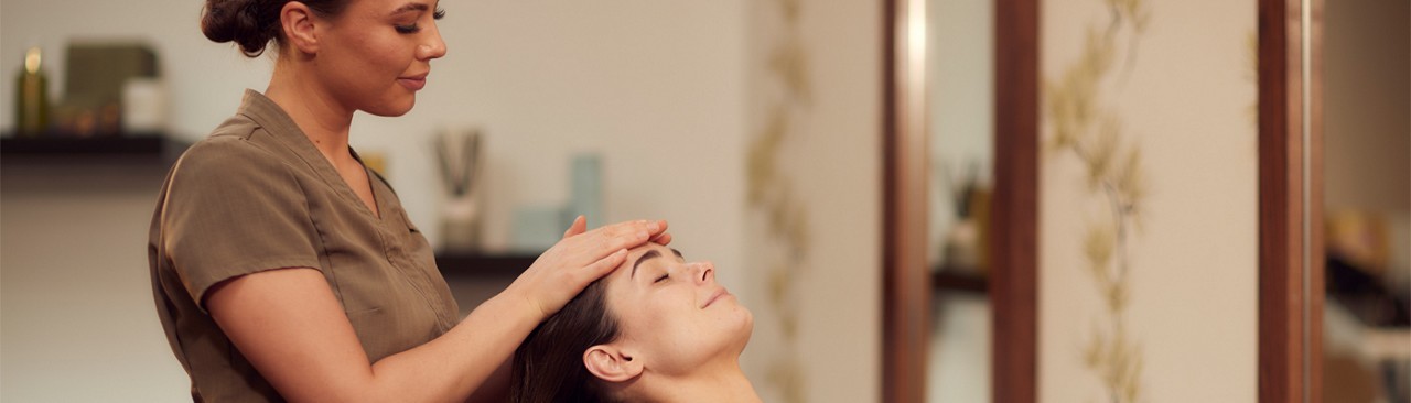 Woman having her head rubbed by a trained spa therapist.