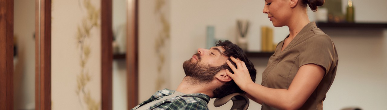 Man having his scalp massaged by a trained therapist.