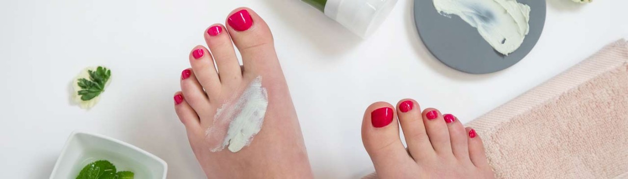feet with painted toe nails and foot cream