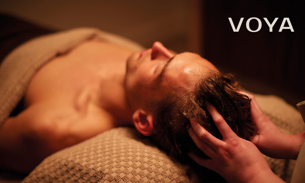 man resting on a spa table getting a head massage