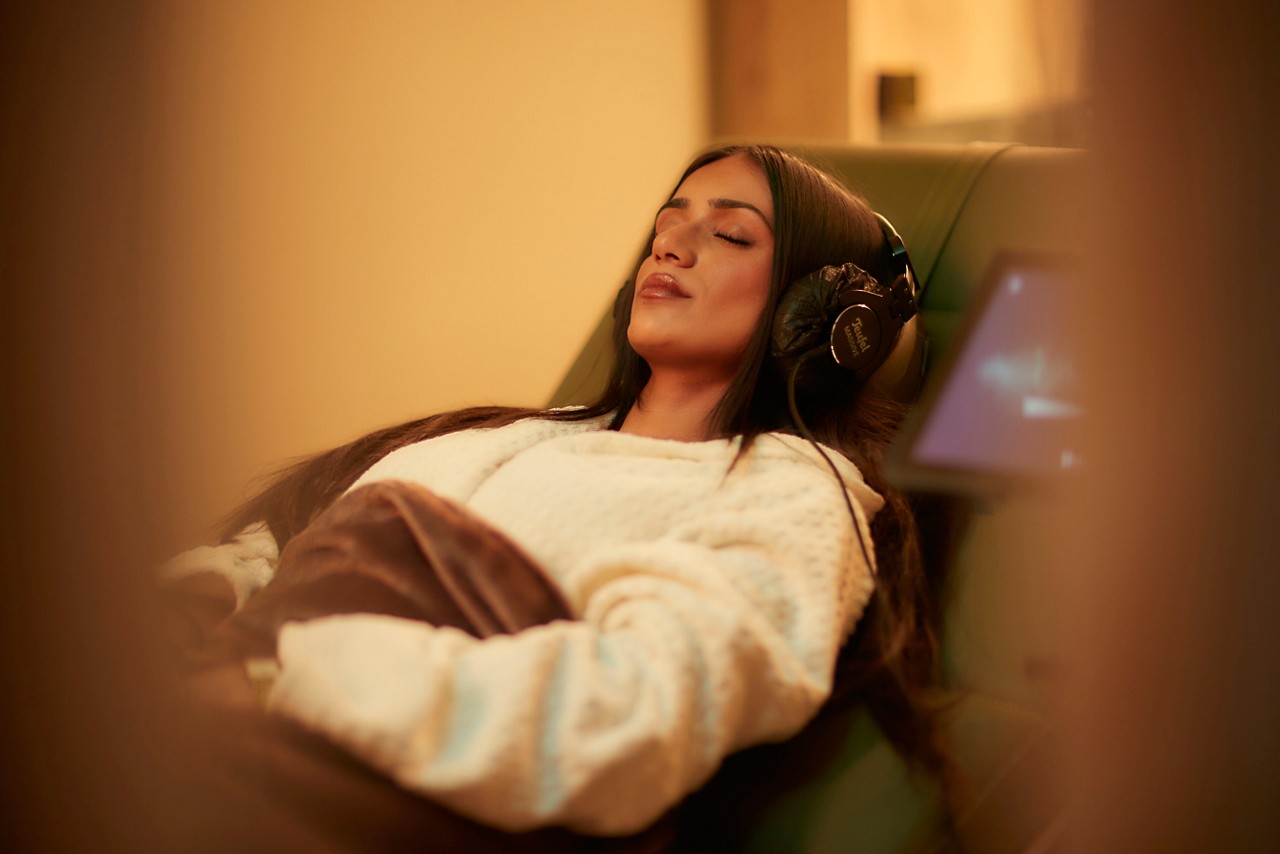 Man laid back in a comfortable chair talking with a spa therapist.